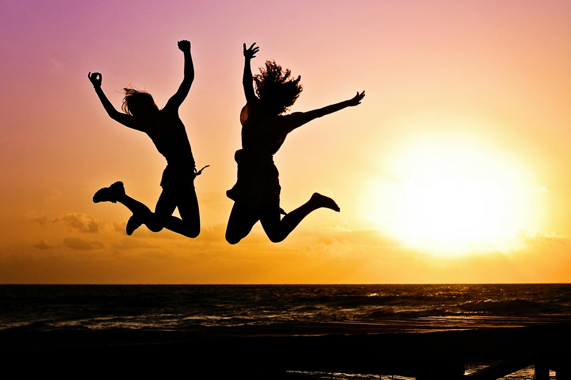 silhouette photography of jump shot of two persons